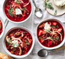 Bortsch in two bowls with herbs sprinkled on top