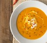 Butternut squash and chilli soup in a bowl, with a swirl of cream
