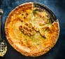 Creamy leek, potato, cheddar & chive fish pie with the first slice cut out