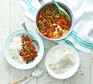 Pot of kidney bean curry next to two bowls of rice