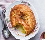 Lemon drizzle sponge pudding with a portion scooped out