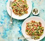 Two plates serving linguine with avocado, tomato & lime