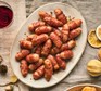 Mini maple & mustard pigs in blankets served on a plate