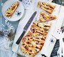 An apple & strawberry pie placed on a chopping board