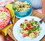 Pesto pasta salad served in tupperware and on a plate