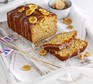 Sliced banana bread topped with drizzle and banana chips on a serving plate