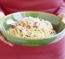 Bowl of spaghetti carbonara with grated parmesan