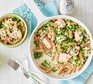 A saucepan and small bowl serving pasta with salmon and peas