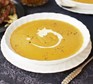 A bowl of sweet potato & butternut squash soup with creme fraiche swirl