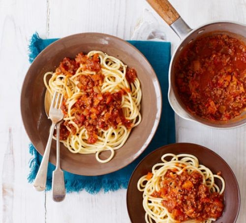 Bolognese recipes spaghetti bolognese on two plates, with sauce in a pan
