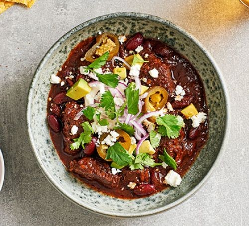 Chilli con carne recipes Chilli con carne topped with feta and salad in a bowl